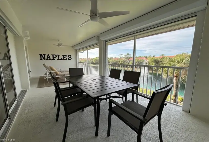 Sunroom / solarium with plenty of natural light, ceiling fan, and a water view