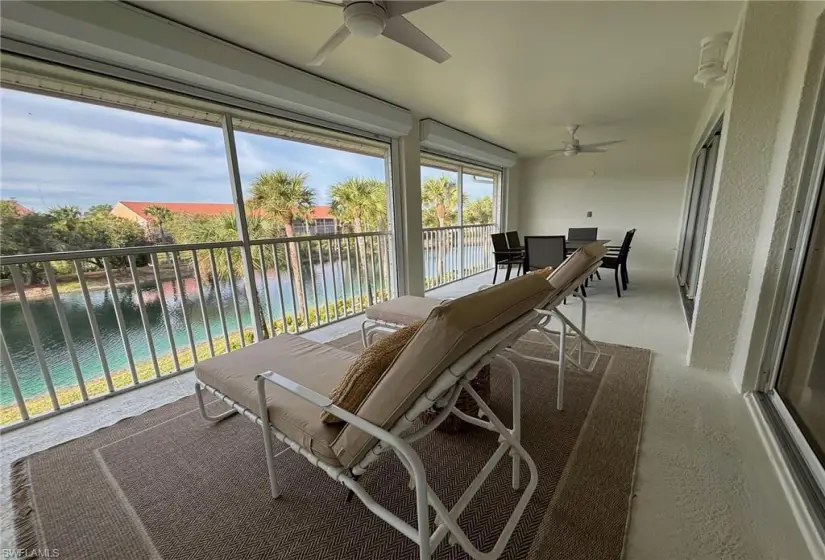 Sunroom featuring ceiling fan and a water view