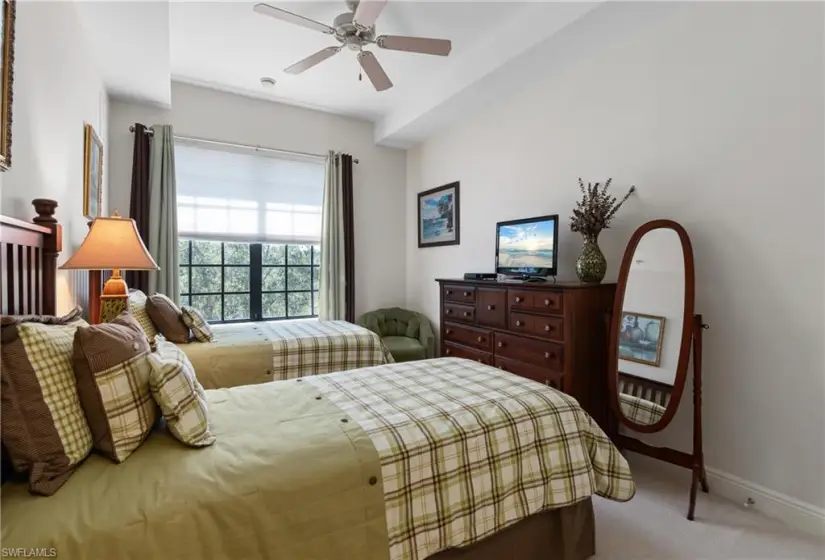 Carpeted bedroom featuring ceiling fan