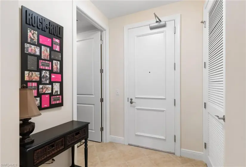 Corridor featuring light tile flooring