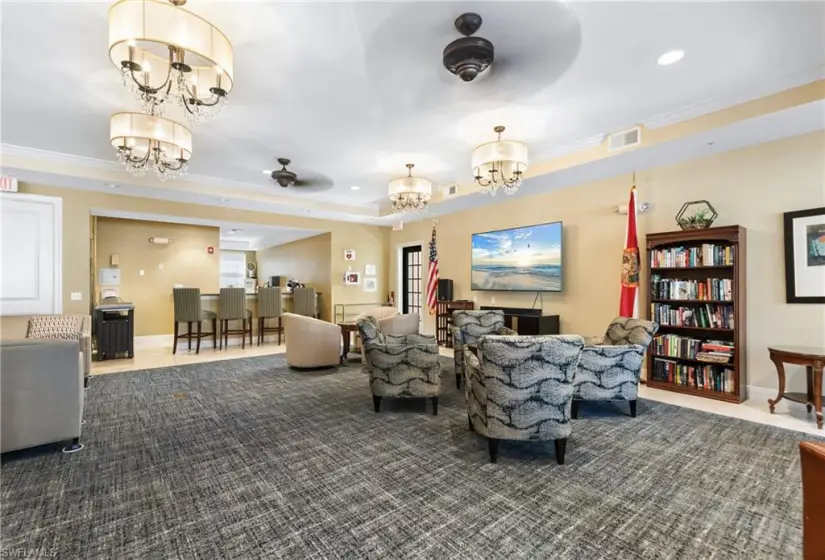 Living room with ceiling fan with notable chandelier and crown molding