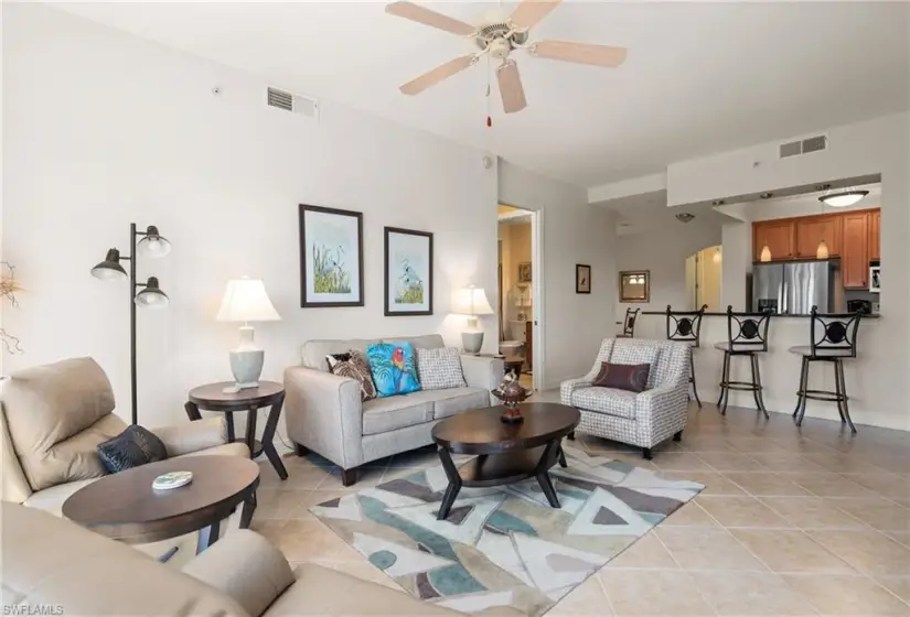 Living room with ceiling fan and light tile floors