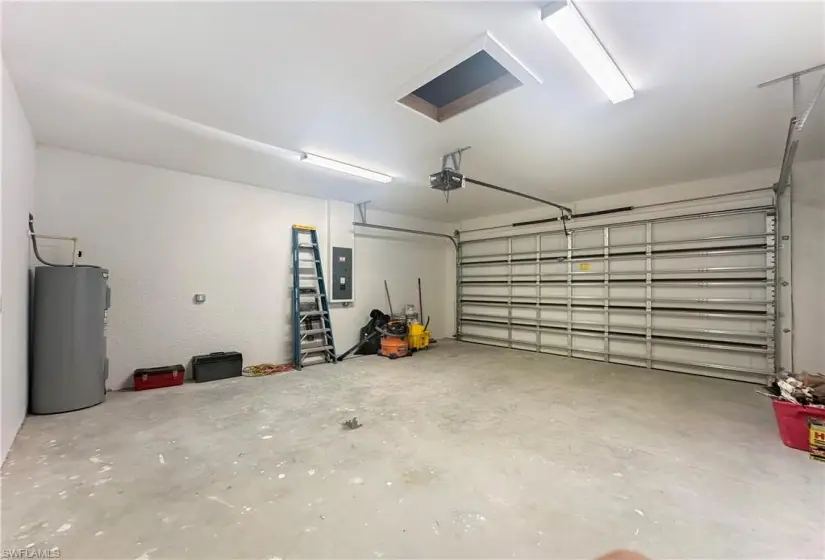 Garage featuring a garage door opener and water heater