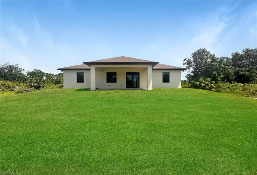 Rear view of property with a lawn