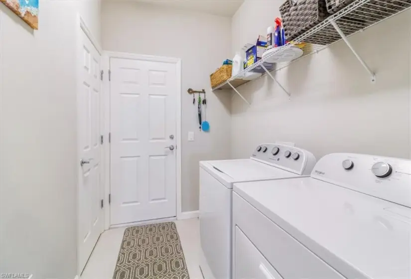 Washroom featuring washer and dryer and light tile flooring