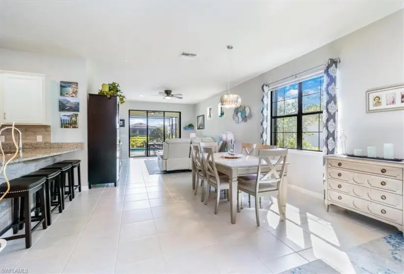 Tiled dining area with ceiling fan and a healthy amount of sunlight