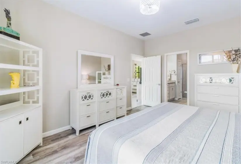 Bedroom with ensuite bathroom and light wood-type flooring